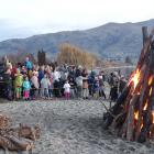 Crowds gather around the bonfires as the temperature started dropping and they waited for the...