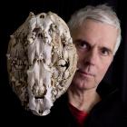 Showing off  a previous work, a bone collage mask, is Dunedin artist and World of WearableArt...