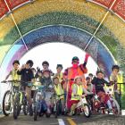 Children prepare for a bicycle race in the rainbow tunnel at the learn-to-cycle track, which...