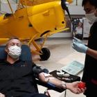 New Zealand Blood Service staff member Gian Daliva helps donor Greg Bramley to give blood in...