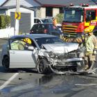 Dunedin firefighters inspect the vehicle left at the scene of a crash at The Glen Saturday....