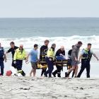 Emergency services carry a patient following a boat capsize in Taieri Mouth on Saturday. One...