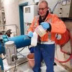 Dunedin City Council wastewater technician Graeme Trainor collects a sample for Covid-19 testing...