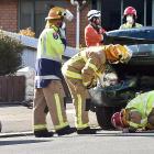 Firemen inspect the damage to a car that hit a power pole at the intersection of Prince Albert Rd...