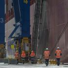 Port Otago workers beside the container ship Rio de Janeiro at Port Chalmers yesterday. All the...