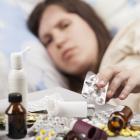 Woman sick in bed with pills, cold. Photo: Getty Images