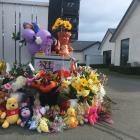 An ever-increasing collection of flowers and toys have been laid on the driveway of the Queen St...