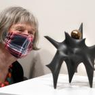 Otago Art Society volunteer Moira Styles admires a Rick Rudd teapot from the Ceramic Association...