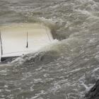 Firefighters secured a car in the choppy Otago Harbour near Glenfalloch this morning. Photo:...