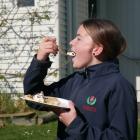 Balmacewen Intermediate pupil Lyla (13) takes a bite of the pancakes her class made to raise...