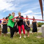 Mayor Lianne Dalziel and Aileen Trist cut the ribbon, watched by Rāwhiti School kapa haka group....