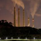 Smoke and steam billows from the coal-fired power plant owned by Indonesia Power, next to an area...
