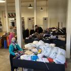 Long-standing volunteer Linda Clapham sorts through donated items in the new basement space at...