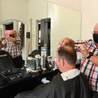 Retiring Oamaru barber Ali Brosnan cuts the hair of Grant Campbell, grandson of his first client...