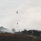 A helicopter empties its bucket in the fight against an out-of-control burn-off near Peebles....