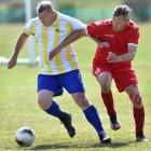 Battling over the ball are Phil Derringer, of the Takapuna Cavaliers, of Auckland (left), and...