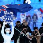 Flag bearers Finn Bilous (left) and Alice Robinson lead the New Zealand team during the Opening...