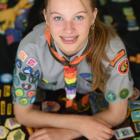 With a blanket dotted with badges collected through her scouting career, Hannah Fleming shows off...
