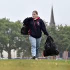Schoolgirl Violet Campbell-Collins cleans up rubbish on North Ground after the rugby ground was...