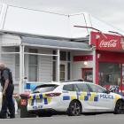 Police cars are parked outside the Mosgiel Mini Mart yesterday as inquiries continue over a...