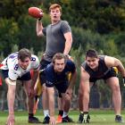 American Football Otago president Tom Rance looks to throw from quarterback as (from left) George...