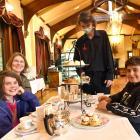 Larnach Castle front of house assistant Finn Cooper serves high tea to Stacey Walden and her...