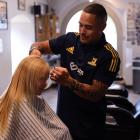 Highlanders team captain Aaron Smith cuts Winton boy Joshua Frazer’s hair at the Bloke Barber in...