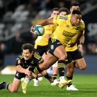 Hurricanes winger Julian Savea attempts to evade the tackle of Highlanders first five Marty Banks...