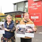 Ukrainians Olha Viazenko and her husband Oleskii Ikonnikov hold posters outside Gardens New World...