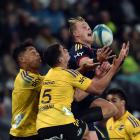 Highlanders wing Sam Gilbert takes a high ball as he is surrounded by Hurricanes players ...