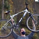 Josh Pendreigh holds up his free bicycle after the Valley Community Workspace giveaway  in...