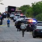 Law enforcement officers at the scene where people were found dead inside a trailer truck in San...