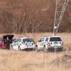 Police by a closed section of Tamblyn Dr in the Roxburgh Hydro Village conduct a search for a...