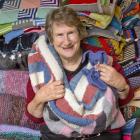 Operation CoverUp Dunedin and Mosgiel co-ordinator Suzanne Lane with some of the knitted blankets...