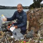 Our Seas Our Future founder Noel Jhinku collects some of the plastic swept ashore in recent...