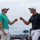 Rory McIlroy (L) and Viktor Hovland celebrate on the 10th hole after scoring an eagle and a...