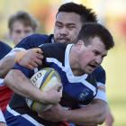 Kaikorai first five Mitchell Taylor is tackled by Harbour flanker Toni Taufa at Watson Park on...