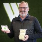 Whitestone Cheese managing director Simon Berry holds a stack of the company's Fuchsia Creek Feta...