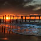 A line of poles stands tall at St Clair Beach in Dunedin during a September sunrise in 2012. — ...