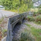 A bridge crosses the dried bed of the River Thames near the river's source at Thames Head. Photo:...