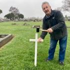 Terry McLaughlin places a makeshift cross on the unmarked grave of Gallipoli veteran Private...