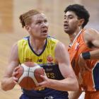 Otago Nuggets player Jack Andrew looks for the hoop as Southland Sharks player Dru-Leo Leusogi...