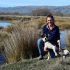 Puketoi Station owner Emma Crutchley pats her heading dog Libby near an oxbow lake on an Upper...