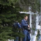 Armed police stand at the door at an address where a grievous assault occurred this morning on...