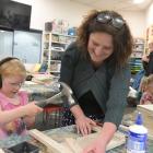Artist Emily Floyd helps Clara Barton (5) build an Enzo Mari chair during one of Floyd’s...