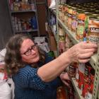 Presbyterian Support Otago foodbank volunteer Karen Judge stacks  cans in the service’s large...