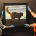 Technician Jon Chapman and head curator pictorial collection Robyn Notman hang Black Cat Walking...
