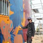 Street artist Koryu Aoshima works on his mural inspired by Roman goddess Minerva near Centre...