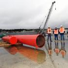 Standing beside the unnamed 14-tonne pile driving hammer yesterday are (from left) site...