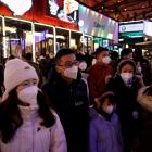 Visitors throng a Beijing shopping complex on New Year's Eve, amid the coronavirus disease...